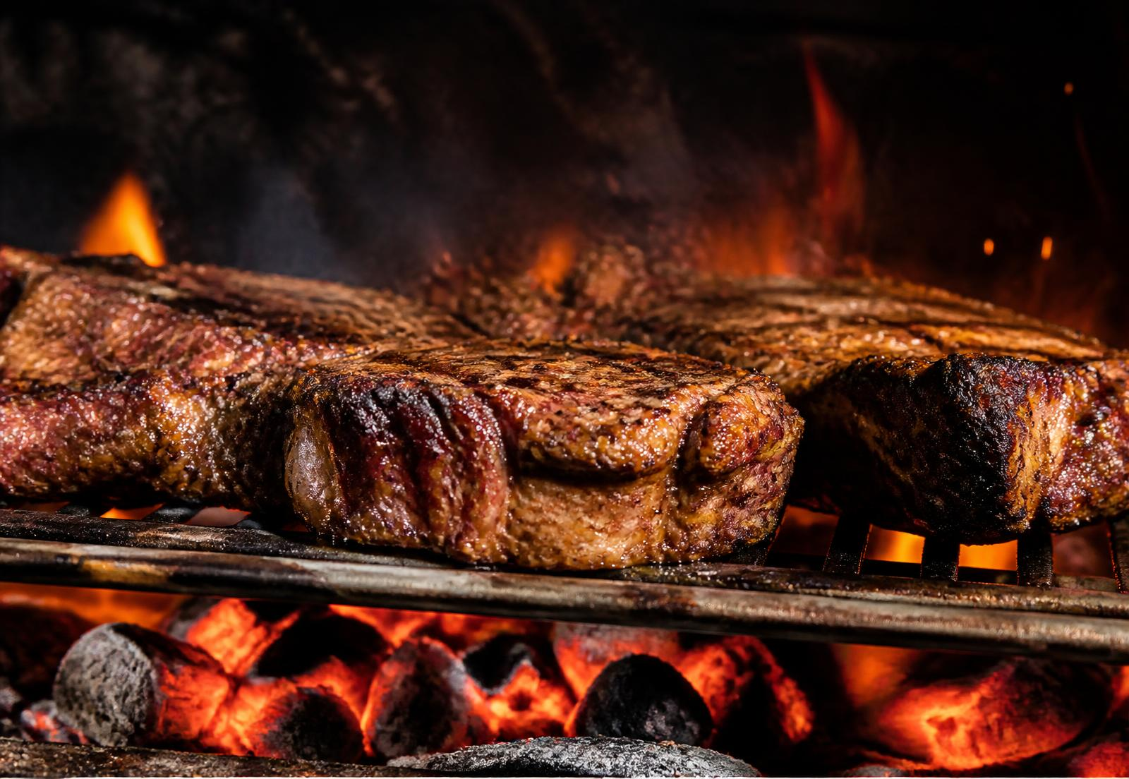 Cortes de carne sobre la parrilla con brasas vivas y llamas